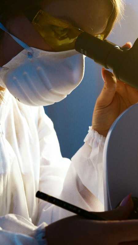 Photo d'une scientifique regardant au microscope